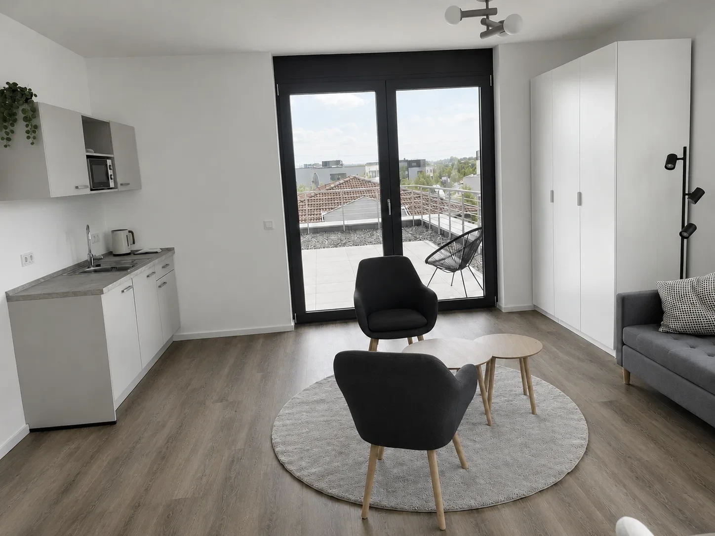 Wohnzimmer mit direktem Zugang zur Dachterrasse im Penthouse Apartment des STAY MCC Boardinghauses Rheinbach